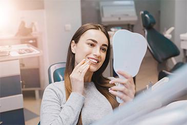 woman looking at her smile after invisalign