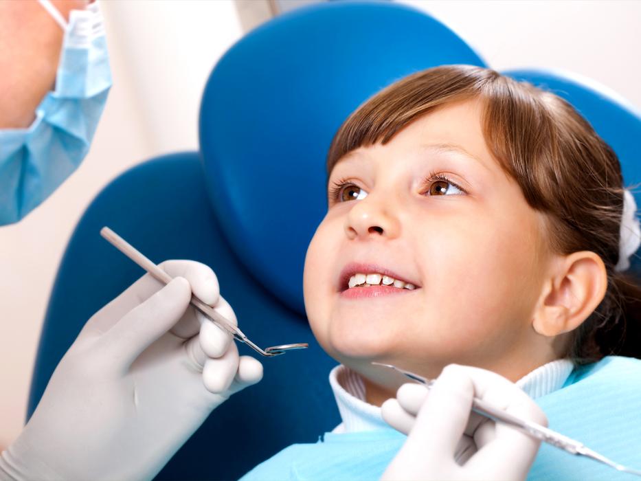 young girl sitting in dental chair 