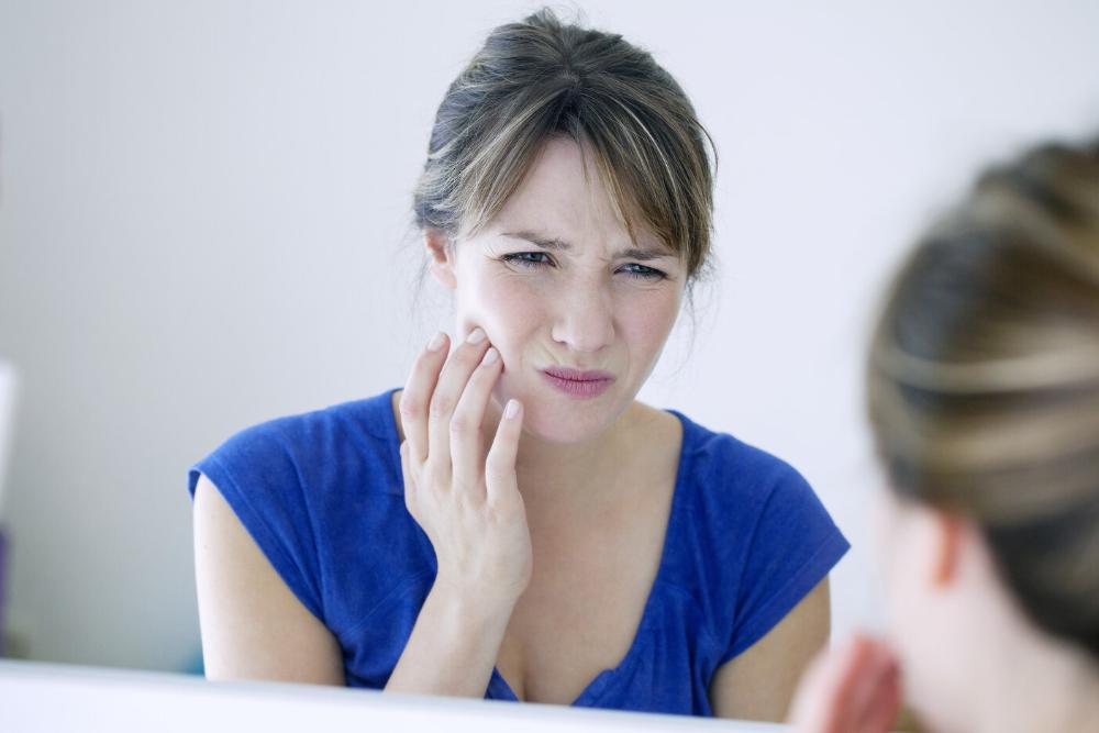 woman holding jaw after her tooth got knocked out