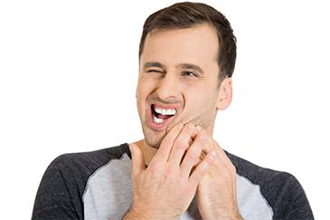 man holding jaw from tooth pain