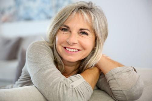 woman wearing greay sweater smiling