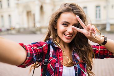 woman smiling and showing a peace sign