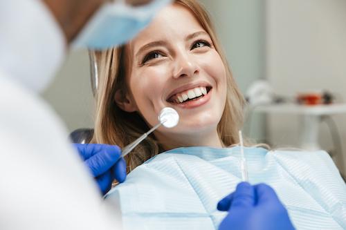 woman sitting in a dental chair while smiling