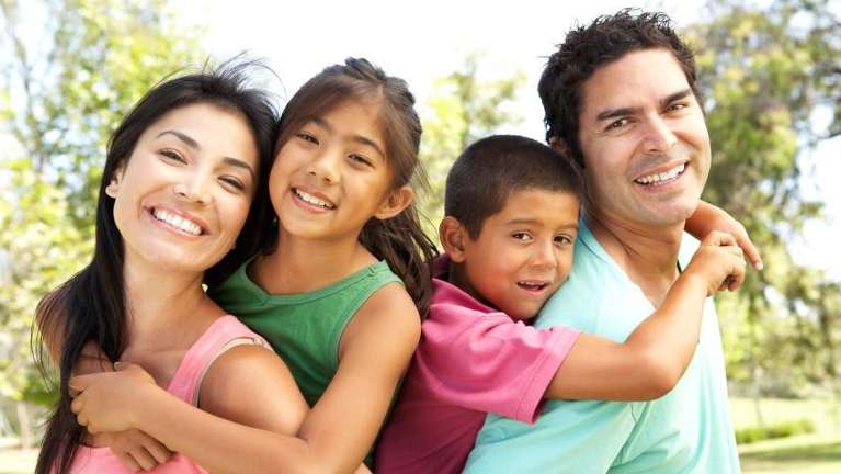 mother, father, son, and daughter smiling