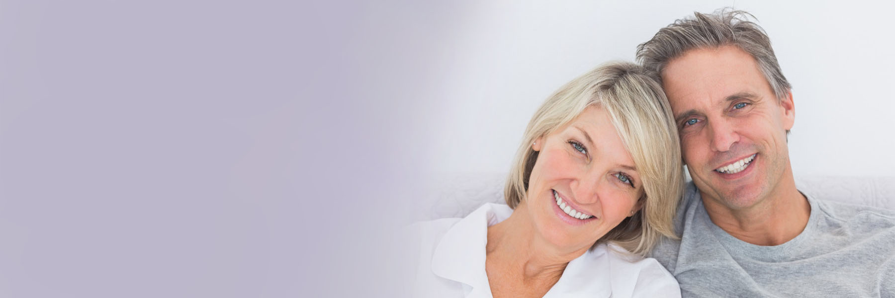 Happy middle-aged couple smiling confidently after affordable root canal treatment in NSW