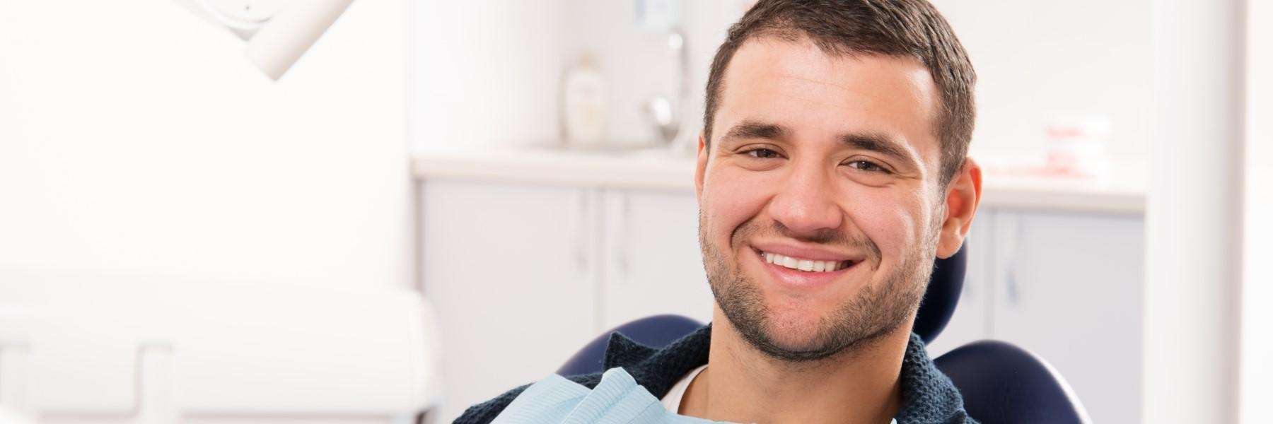 man smiling in dental chair after a root canal in blacktown