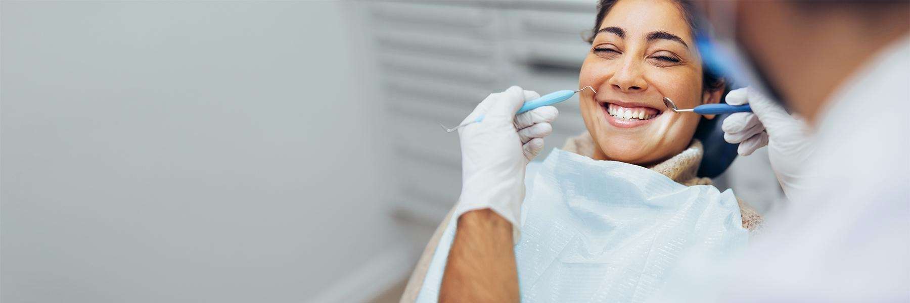 woman smiling in dental chair after tooth extraction
